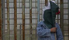 Una persona protesta contra la construcción del muro en la frontera entre Tijuana y San Diego