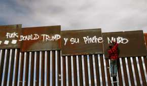 Un activista mexicano pinta unas vallas que dividen a Ciudad Juárez, Chihuahua, de El Paso, Texas