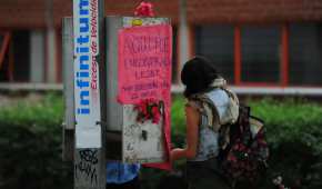 Una joven coloca una ofrenda en el sitio donde fue hallada muerta una joven en Ciudad Universitaria