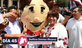 Delfina Gómez posa junto con una botarga durante un evento de campaña