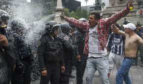 Un aficionado rocía de espuma a policías de la Ciudad de México luego del triunfo de México