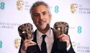 El mexicano Alfonso Cuarón sosteniendo dos de los 4 premios Bafta que ganó este domingo