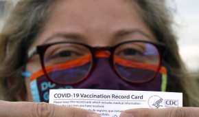Alejandra, una dentista mexicana, posa con su tarjeta de vacunación otorgada por el gobierno de EU