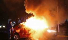 Elementos de la policía de Zapopan atienden los vehículos incendiados por criminales