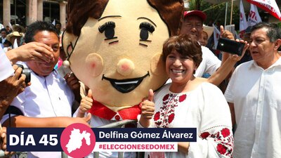 Delfina Gómez posa junto con una botarga durante un evento de campaña