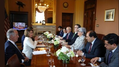 Roberto Velasco (derecha) comiendo cacahuates durante reunión con funcionarios de EU