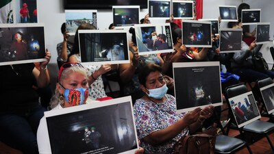 Viudas de los mineros que fallecieron muestran imágenes dentro de la mina el 25 de mayo de 2021.