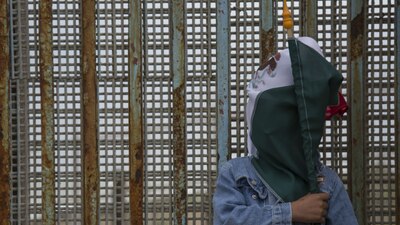 Una persona protesta contra la construcción del muro en la frontera entre Tijuana y San Diego