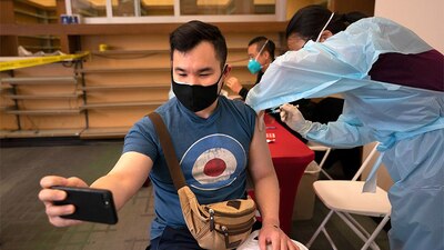 Freeson Wong, ciudadano estadounidense, tomándose una selfie mientras recibe la vacuna Moderna en Los Ángeles, California