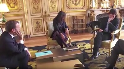 El presidente de Francia (izquierda) observa mientras su perro se orina en una reunión con ministros