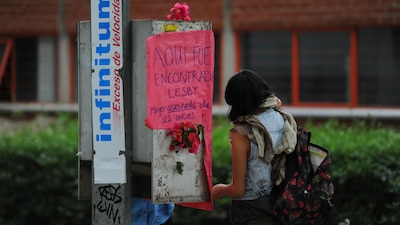 Una joven coloca una ofrenda en el sitio donde fue hallada muerta una joven en Ciudad Universitaria