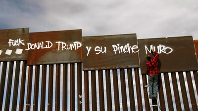 Un activista mexicano pinta unas vallas que dividen a Ciudad Juárez, Chihuahua, de El Paso, Texas