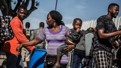 Un grupo de migrantes centroamericanos y haitianos en un puente fronterizo de Tijuana, Baja California