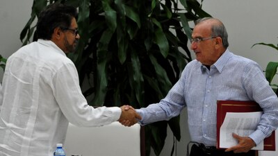 El comandante de la guerrila Iván Márquez saluda a Humberto de la Calle, el negociador del gobierno colombiano.
