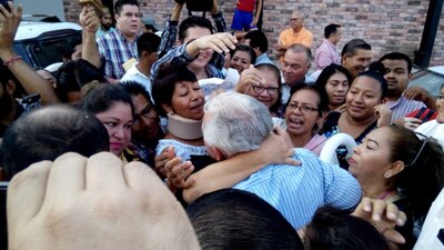 Andrés Granier Melo (centro) es abrazado por una mujer previo a que entrara a una estación de radio en Centro