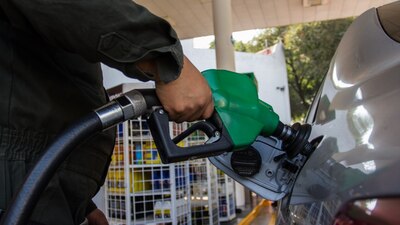Un trabajador de una gasolinera atiende a un cliente