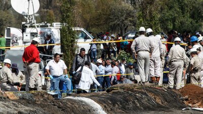 Personal de Pemex trabajando en el lugar donde explotó una toma clandestina