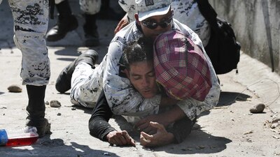 Un elemento de la Guardia Nacional contiene a un migrante que cruzó la frontera sur