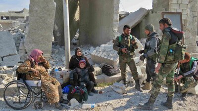 Fuerzas del gobierno sirio junto a los civiles después de recuperar uno de los cuadrantes del este de la ciudad