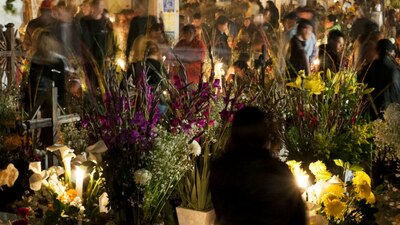 Personas celebran el Día de Muertos en el cementerio de San Andrés Mixquic, en la delegación Tláhuac