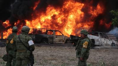 Militares observan un incendio a consecuencia de una toma clandestina de combustible en Amozoc, Puebla
