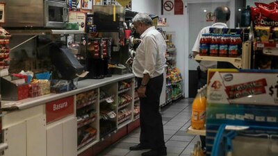 El presidente tomando su café de una maquina dentro de la tienda