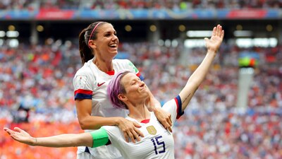 La veterana estadounidense Megan Rapinoe (cabello morado) no cantó el himno de EU como protesta contra la FIFA