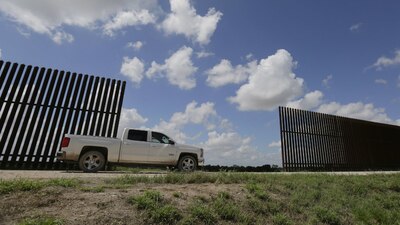 Un ranchero texano pasa en su auto por la cerca divide el terreno