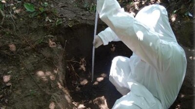 Un perito de la Fiscalía General de Veracruz inspecciona una fosa clandestina en Xalapa