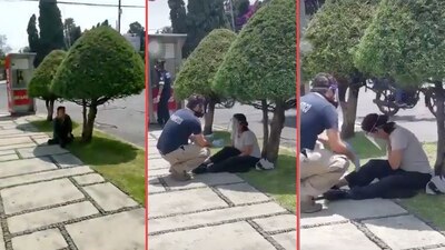 Una mujer, aparentemente con síntomas de COVID-19, es auxiliada por personal médico